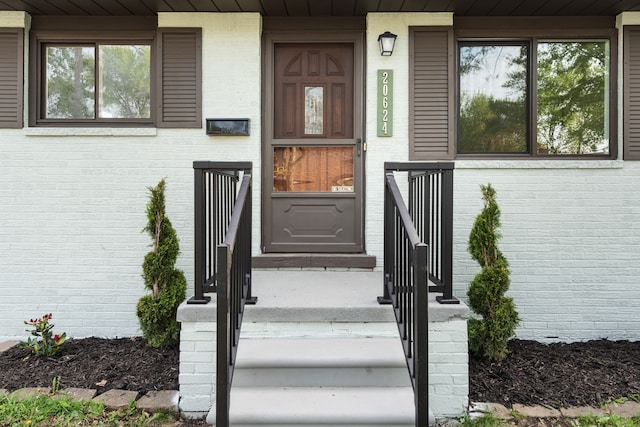 doorway to property with brick siding