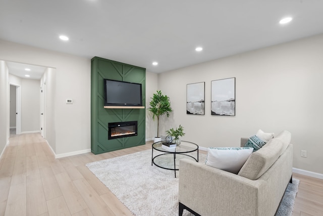 living area with light wood-style flooring, a fireplace, baseboards, and recessed lighting