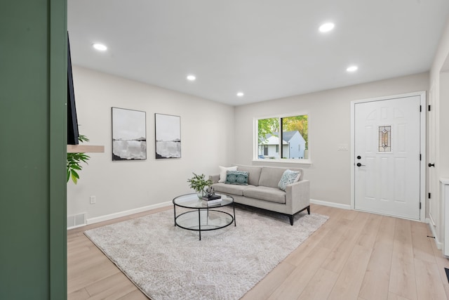 living room with light wood-type flooring, recessed lighting, and baseboards