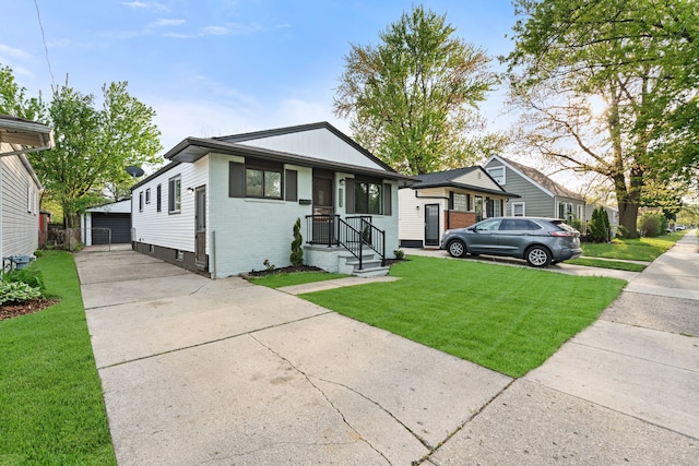 view of front facade featuring brick siding, an outbuilding, a front yard, and a detached garage