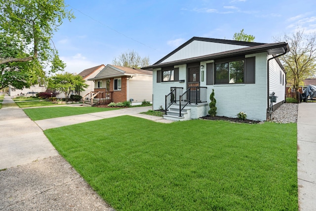 bungalow-style house featuring brick siding and a front lawn