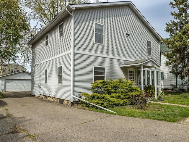 view of side of home featuring a detached garage and an outdoor structure