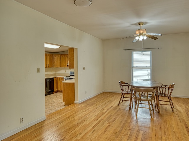 dining area featuring a ceiling fan, baseboards, and light wood-style floors