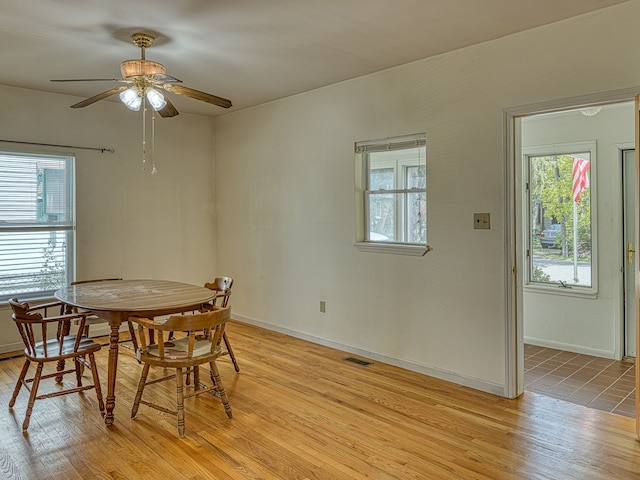 dining area with visible vents, a ceiling fan, light wood-style floors, and plenty of natural light