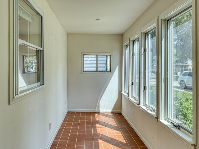 unfurnished sunroom with baseboards and a healthy amount of sunlight