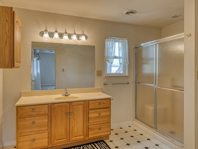 full bath featuring vanity, visible vents, baseboards, tile patterned floors, and a shower stall