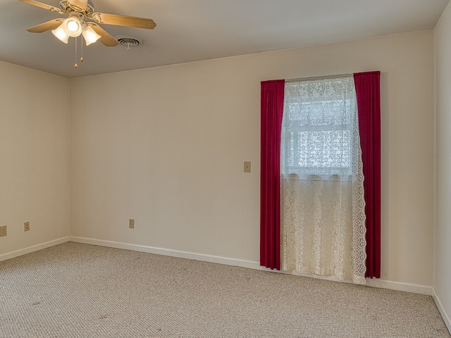spare room featuring visible vents, a ceiling fan, carpet, and baseboards