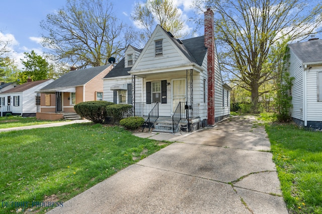 view of front of house with driveway, a front yard, and a chimney