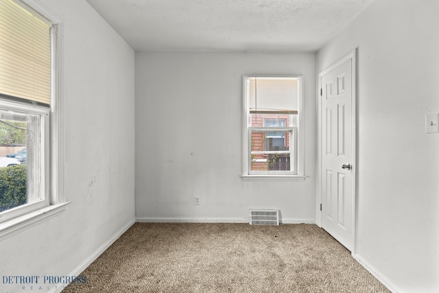 empty room featuring carpet floors, baseboards, and visible vents