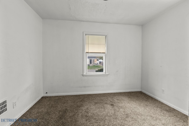 empty room with baseboards, carpet, and visible vents