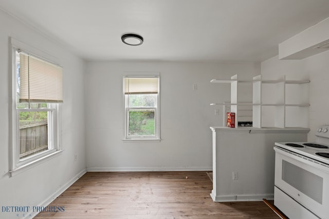 kitchen with white electric range, baseboards, and wood finished floors