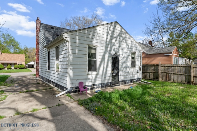 rear view of house featuring fence and a chimney