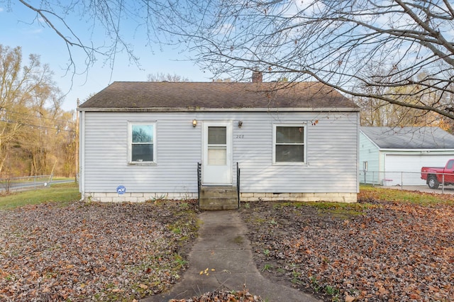 view of front of home with entry steps, fence, a chimney, and roof with shingles