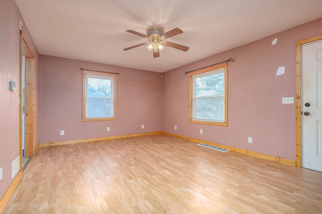 unfurnished room with light wood-style floors, baseboards, a ceiling fan, and visible vents