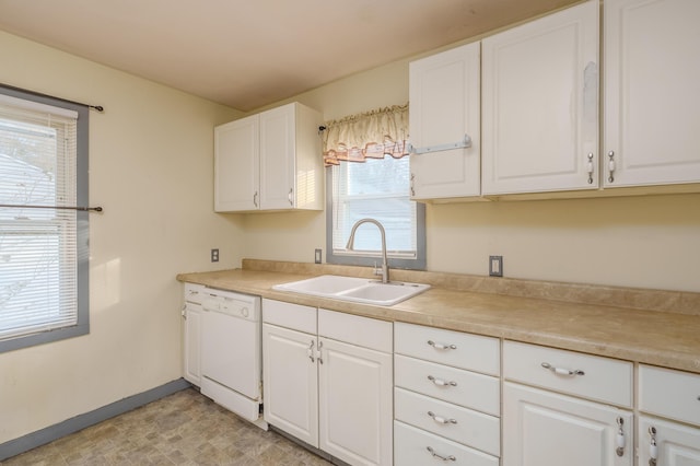 kitchen with baseboards, white dishwasher, a sink, and white cabinetry