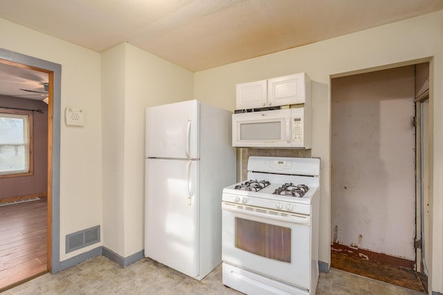 kitchen featuring visible vents, white appliances, baseboards, white cabinets, and a ceiling fan