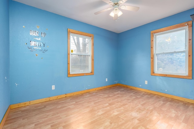 spare room featuring baseboards, ceiling fan, and wood finished floors