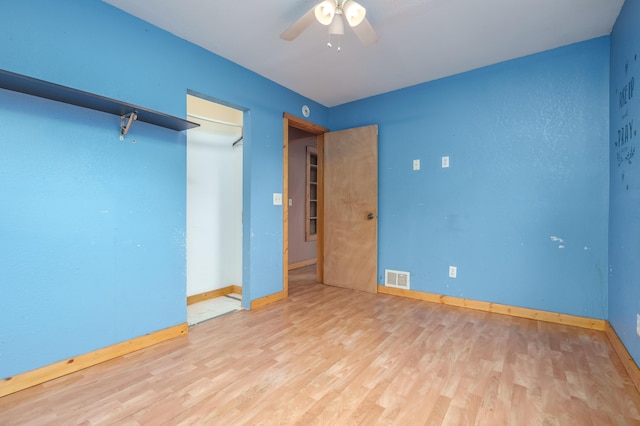unfurnished bedroom featuring visible vents, a ceiling fan, baseboards, and wood finished floors