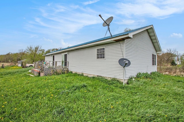 view of side of home with a yard and a wooden deck