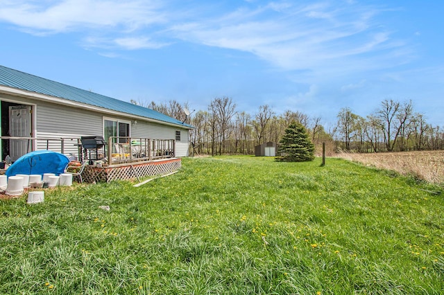 view of yard featuring a storage unit and a deck