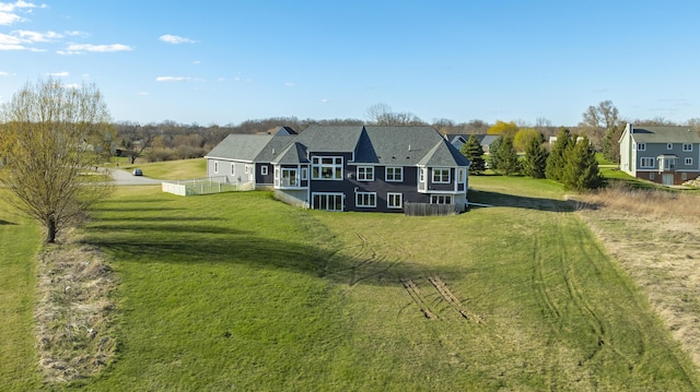 back of house with a lawn and fence