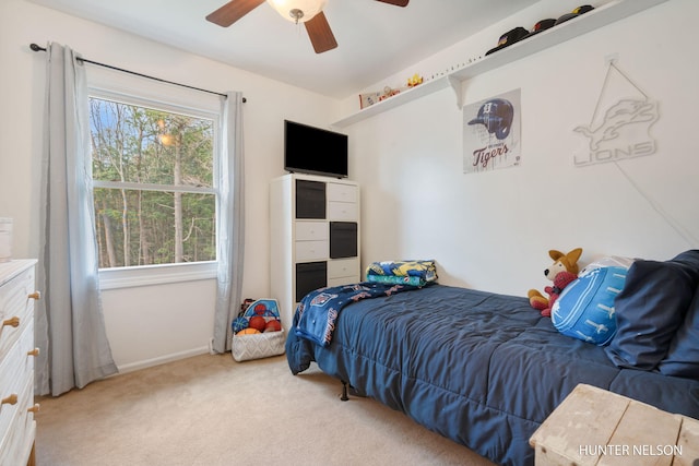 carpeted bedroom featuring baseboards and a ceiling fan
