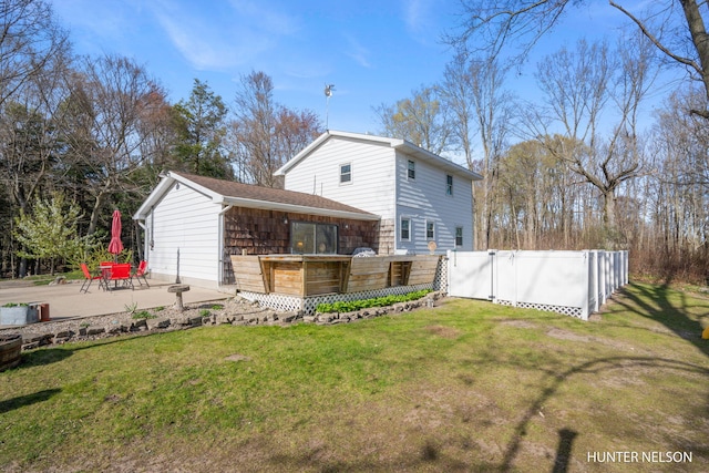 back of property with a lawn, fence, and a patio area