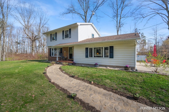 traditional home featuring covered porch, brick siding, and a front yard