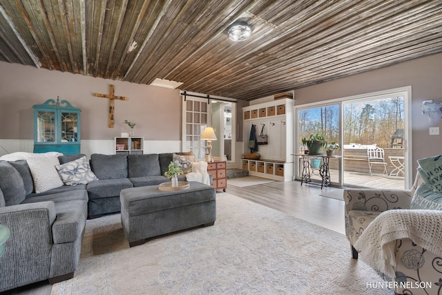living room with a barn door and wood finished floors