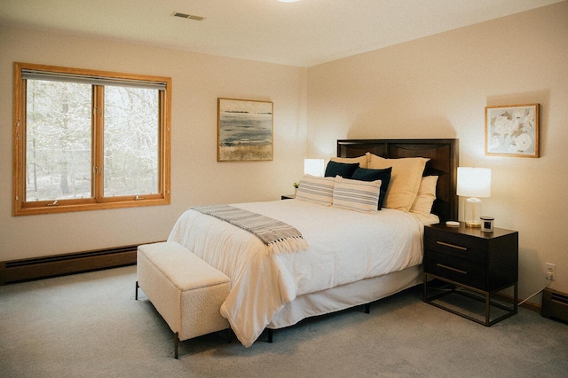 bedroom featuring visible vents, carpet floors, and a baseboard heating unit