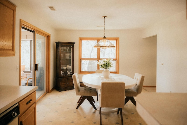 dining area with visible vents, baseboards, a wealth of natural light, and light carpet
