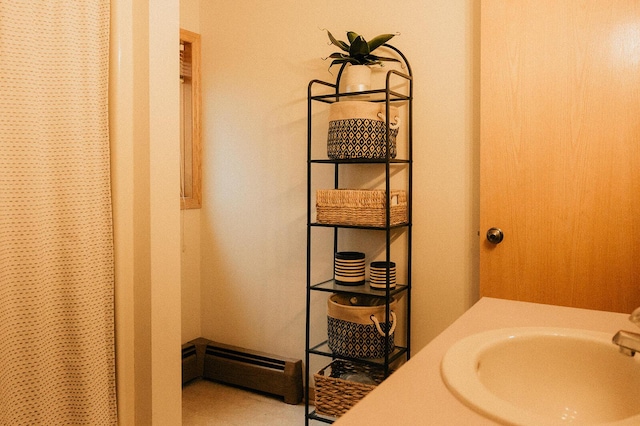 bathroom with a shower with curtain, a sink, and baseboard heating