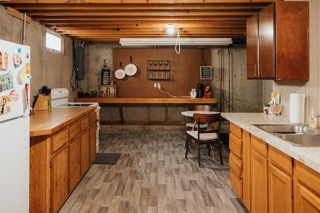 bar featuring white appliances, a sink, and light wood-type flooring