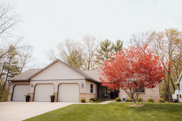 view of front facade with brick siding, driveway, a front lawn, and a garage