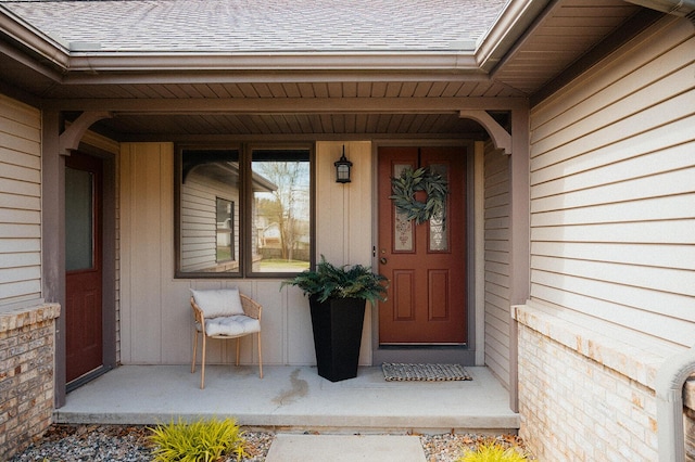 entrance to property with a shingled roof and board and batten siding
