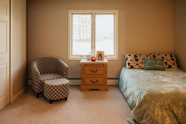 bedroom featuring light carpet and a baseboard heating unit