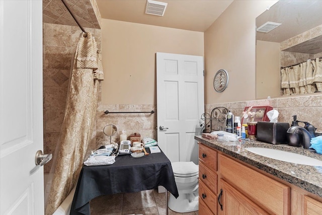 full bathroom featuring visible vents, tile patterned floors, toilet, and tile walls