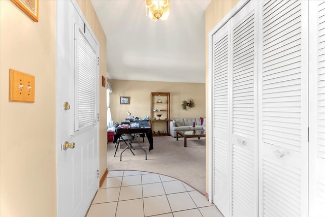 hallway featuring light colored carpet and light tile patterned flooring