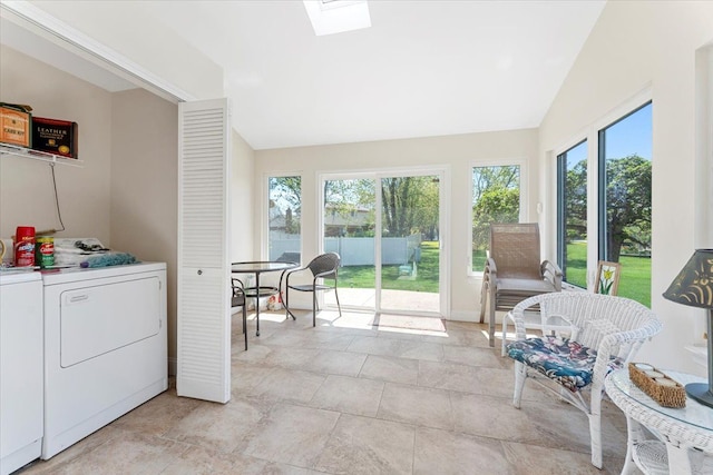 sunroom featuring separate washer and dryer, vaulted ceiling with skylight, and a healthy amount of sunlight