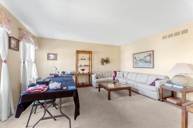 living area with visible vents and light carpet