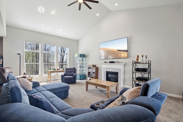 living room with ceiling fan, carpet floors, a premium fireplace, high vaulted ceiling, and baseboards