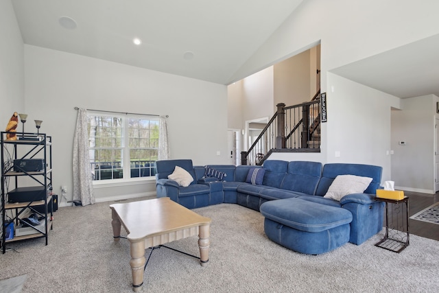 living room with stairs, high vaulted ceiling, and baseboards