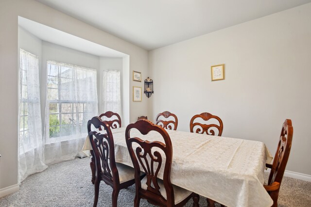 carpeted dining area with baseboards