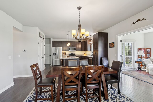dining area featuring baseboards, a chandelier, and dark wood-style floors