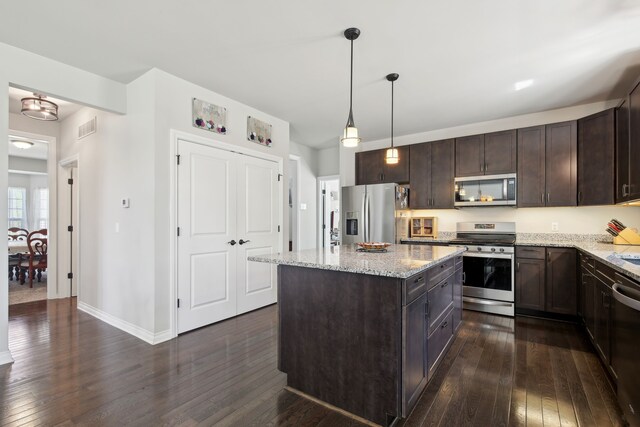 kitchen featuring visible vents, light stone countertops, dark brown cabinets, stainless steel appliances, and dark wood-type flooring