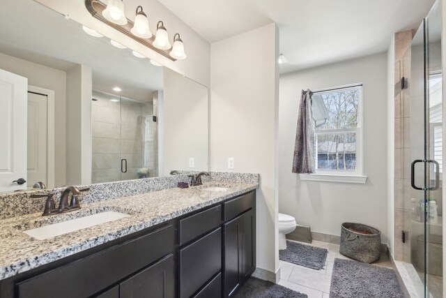full bath with double vanity, a sink, a stall shower, and tile patterned floors