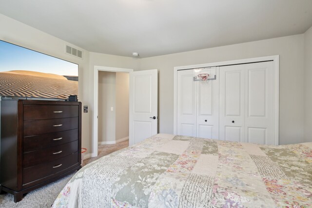 bedroom with baseboards, visible vents, carpet, and a closet