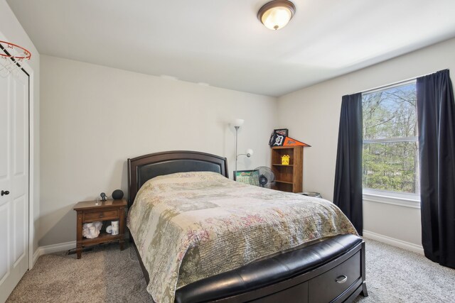 bedroom with baseboards and light colored carpet