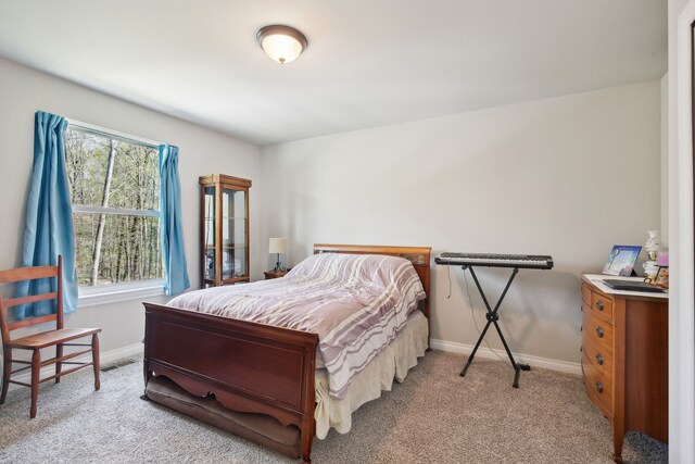 bedroom with baseboards, light colored carpet, and visible vents