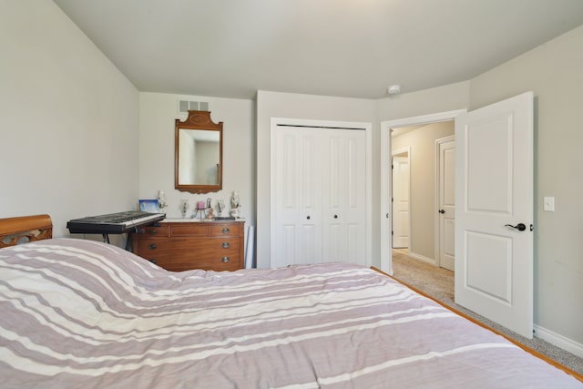 bedroom featuring baseboards, visible vents, carpet, and a closet